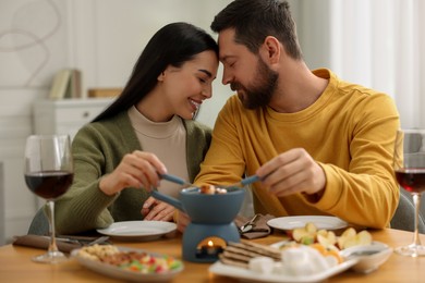 Photo of Romantic date with fondue. Couple enjoying each other at home