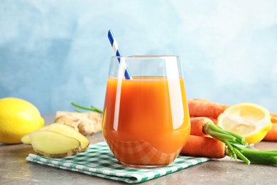 Photo of Glass with carrot juice and fresh ingredients on table