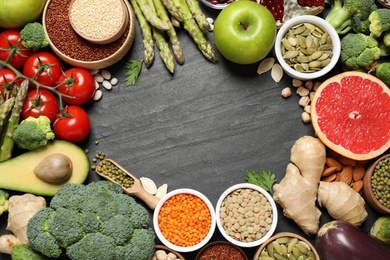 Frame of fresh vegetables, fruits and seeds on black table, flat lay. Space for text