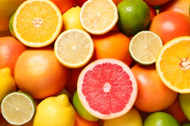 Different fresh citrus fruits as background, top view