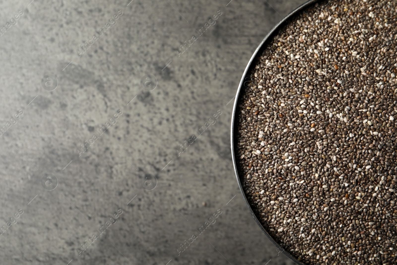 Photo of Bowl with chia seeds on grey table, top view. Space for text