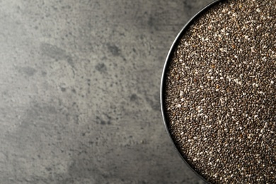 Photo of Bowl with chia seeds on grey table, top view. Space for text