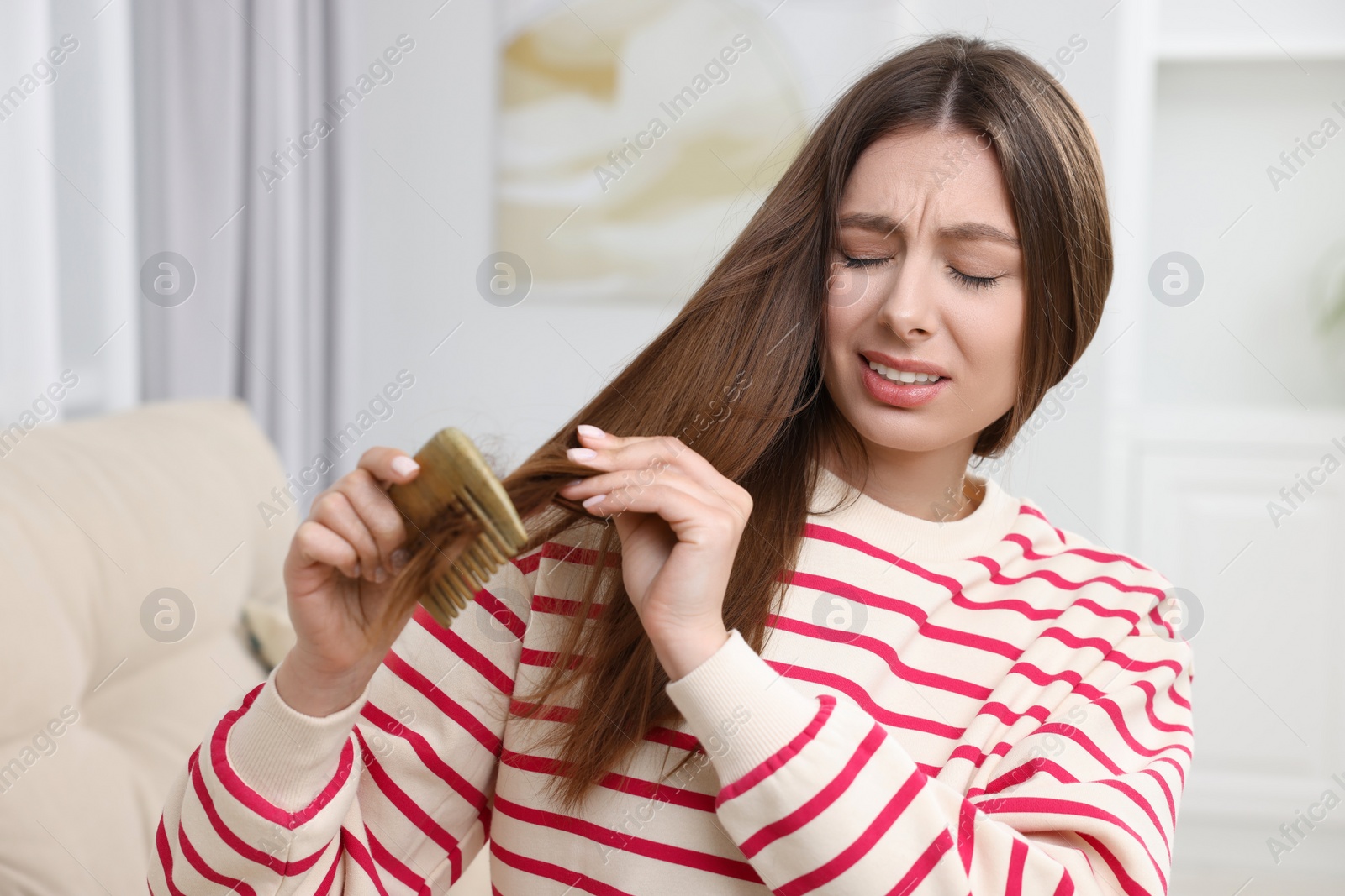 Photo of Upset woman brushing her hair at home. Alopecia problem