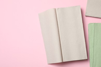 Photo of Paper napkins on pink background, flat lay. Space for text