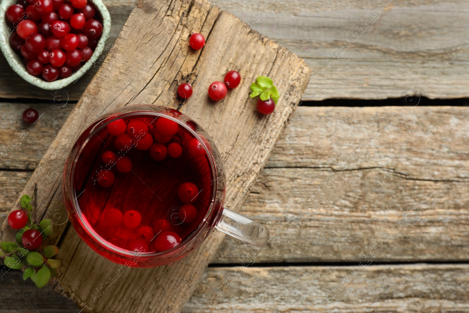 Photo of Delicious cranberry tea and berries on wooden table, flat lay. Space for text