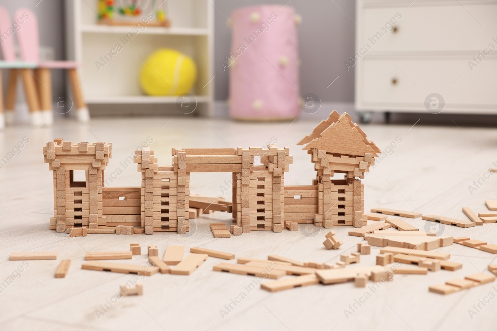 Photo of Wooden construction set on floor indoors. Children's toy