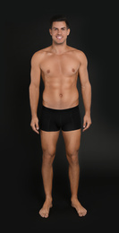 Handsome man in underwear on black background