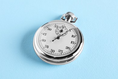 Photo of Vintage timer on light blue background. Measuring tool