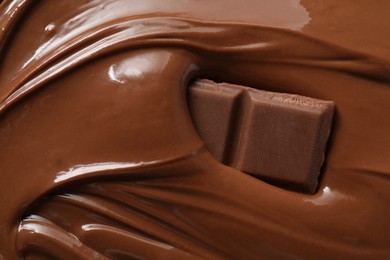 Photo of Tasty milk chocolate paste and pieces as background, closeup