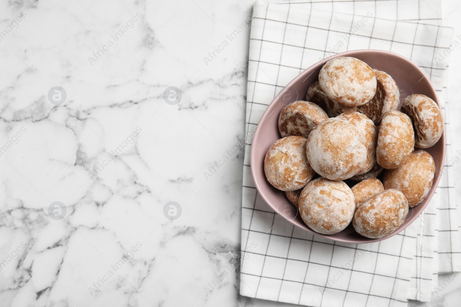 Photo of Tasty homemade gingerbread cookies in bowl on white marble table, top view. Space for text