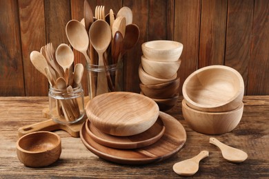 Many different wooden dishware and utensils on table