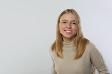 Portrait of beautiful young woman in stylish sweater on white background. Space for text