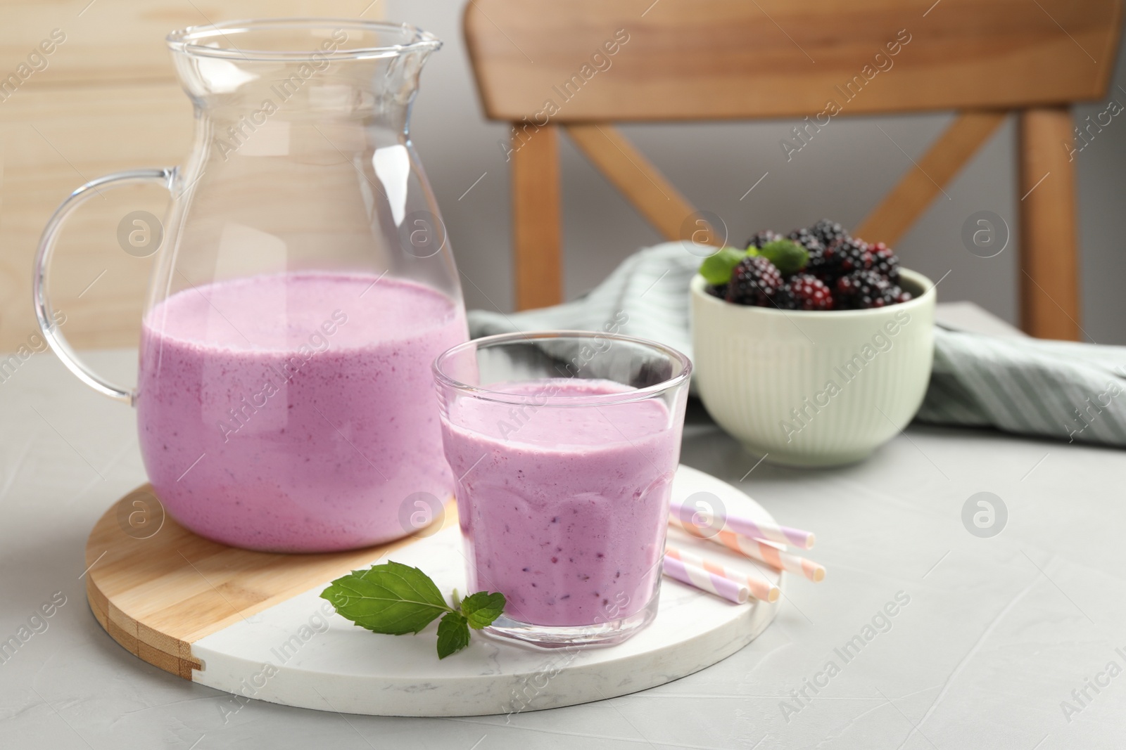 Photo of Delicious blackberry smoothie and mint on white table indoors, space for text