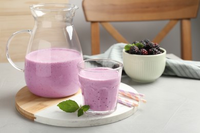 Delicious blackberry smoothie and mint on white table indoors, space for text