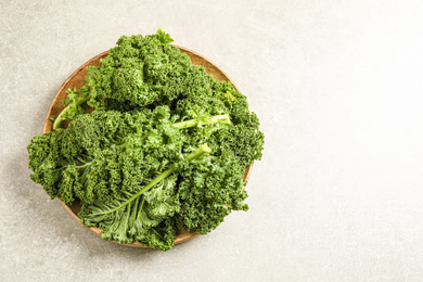 Fresh kale leaves on light grey table, top view. Space for text