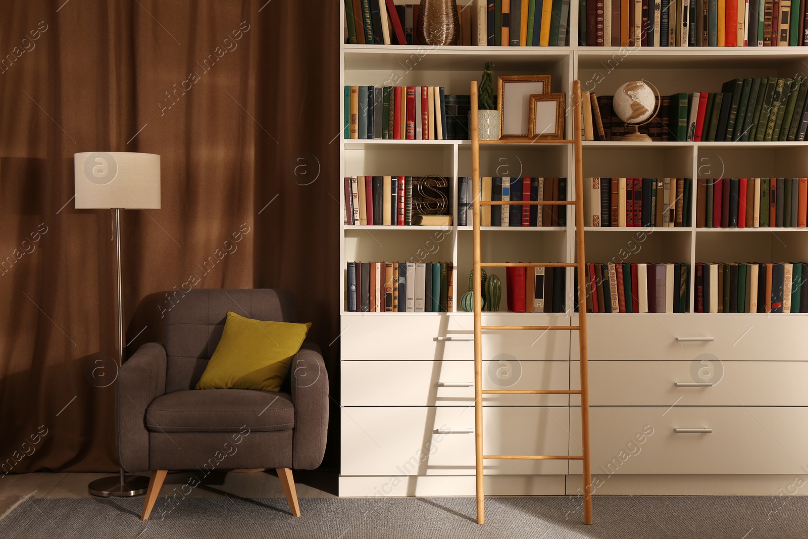 Photo of Cozy home library interior with collection of different books on shelves and comfortable place for reading