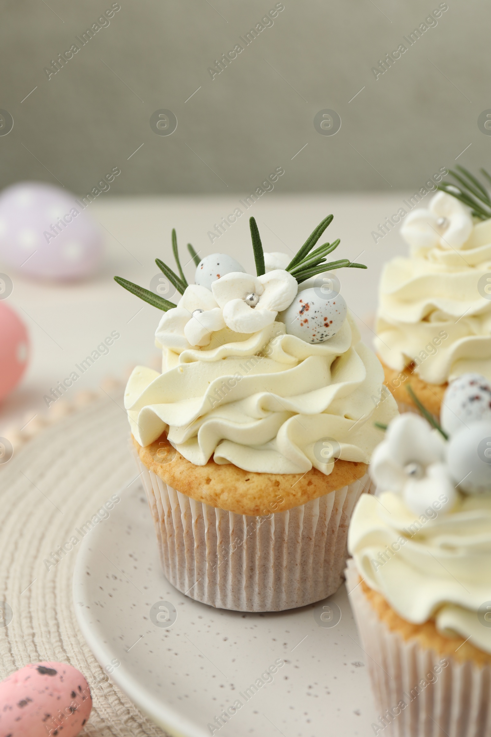 Photo of Tasty Easter cupcakes with vanilla cream on table