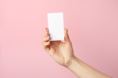 Photo of Woman holding blank business card on pink background, closeup. Mockup for design