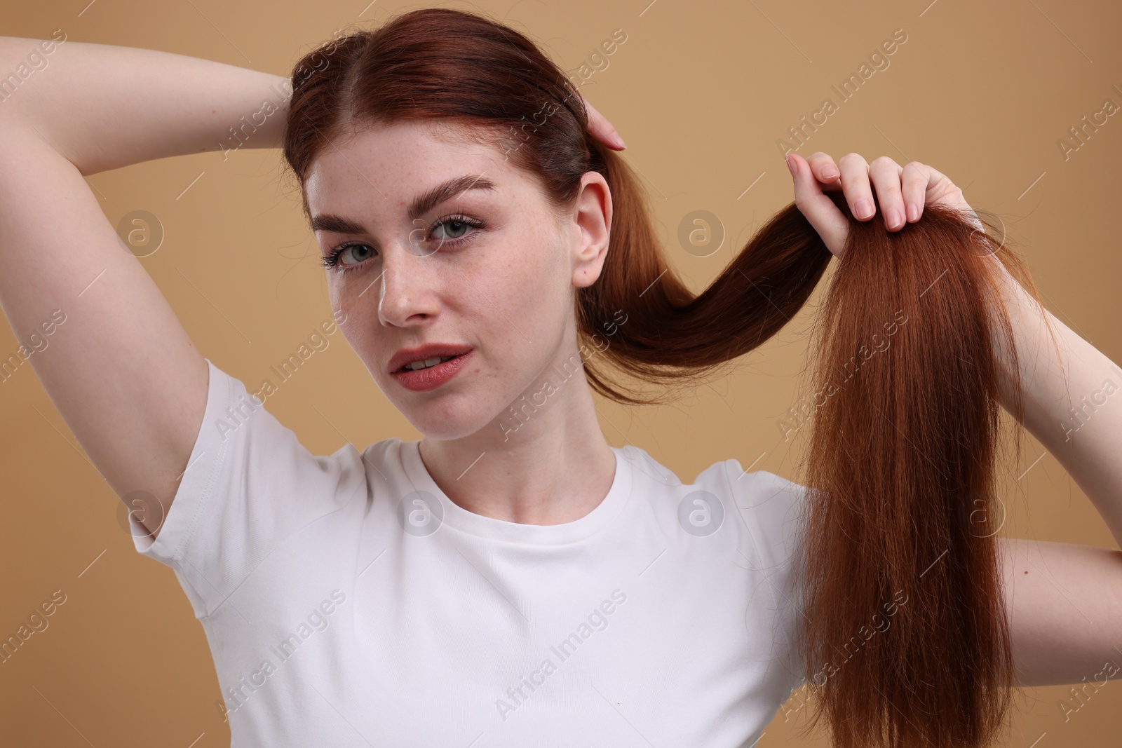 Photo of Portrait of beautiful woman with freckles on beige background