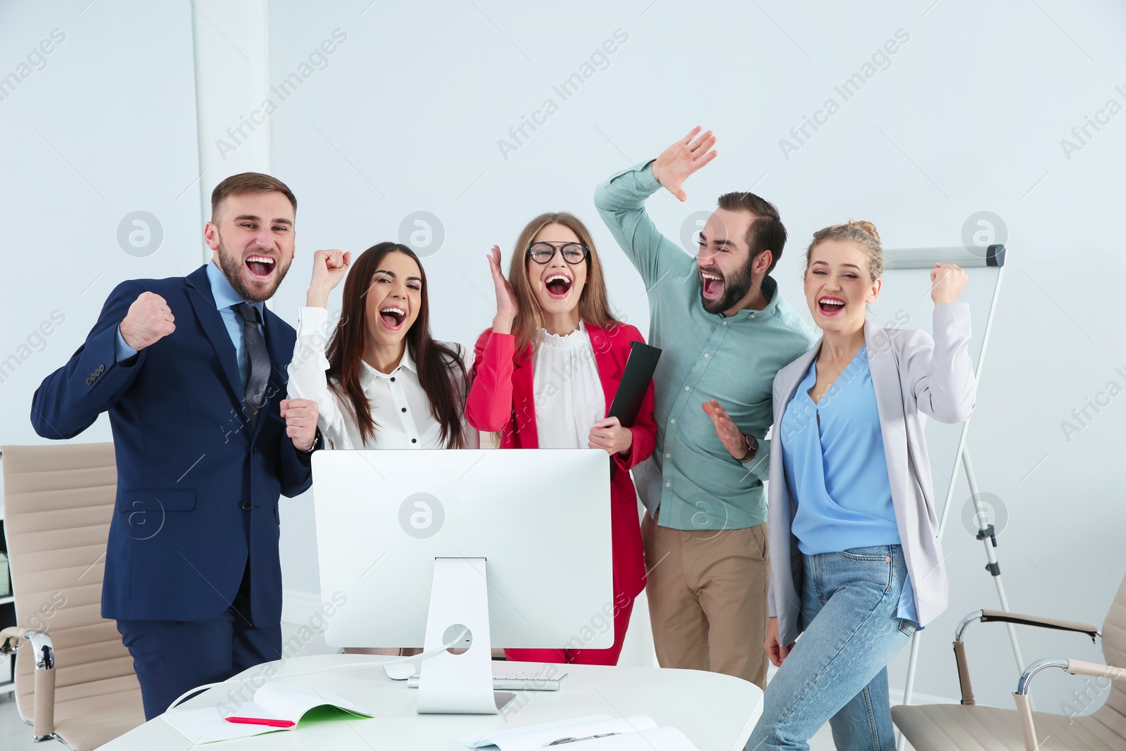 Photo of Group of office employees celebrating victory at workplace