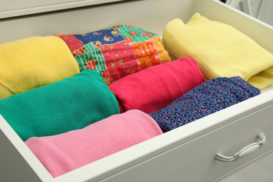 Photo of Folded clothes in open drawer. Apparel storage