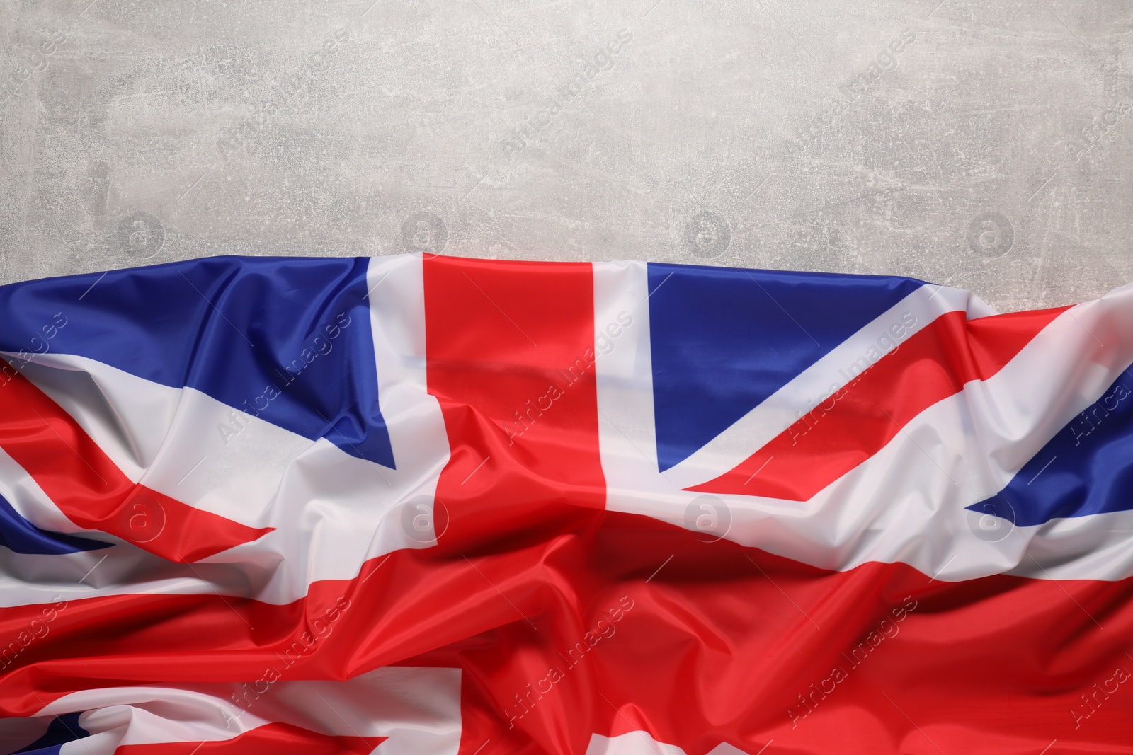 Photo of Flag of United Kingdom on light gray background, top view. Space for text