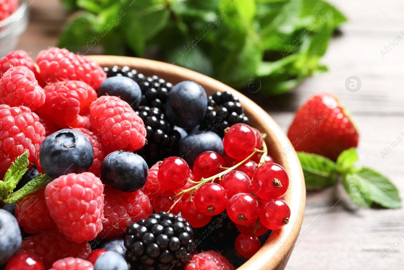 Photo of Bowl with raspberries and different berries, closeup