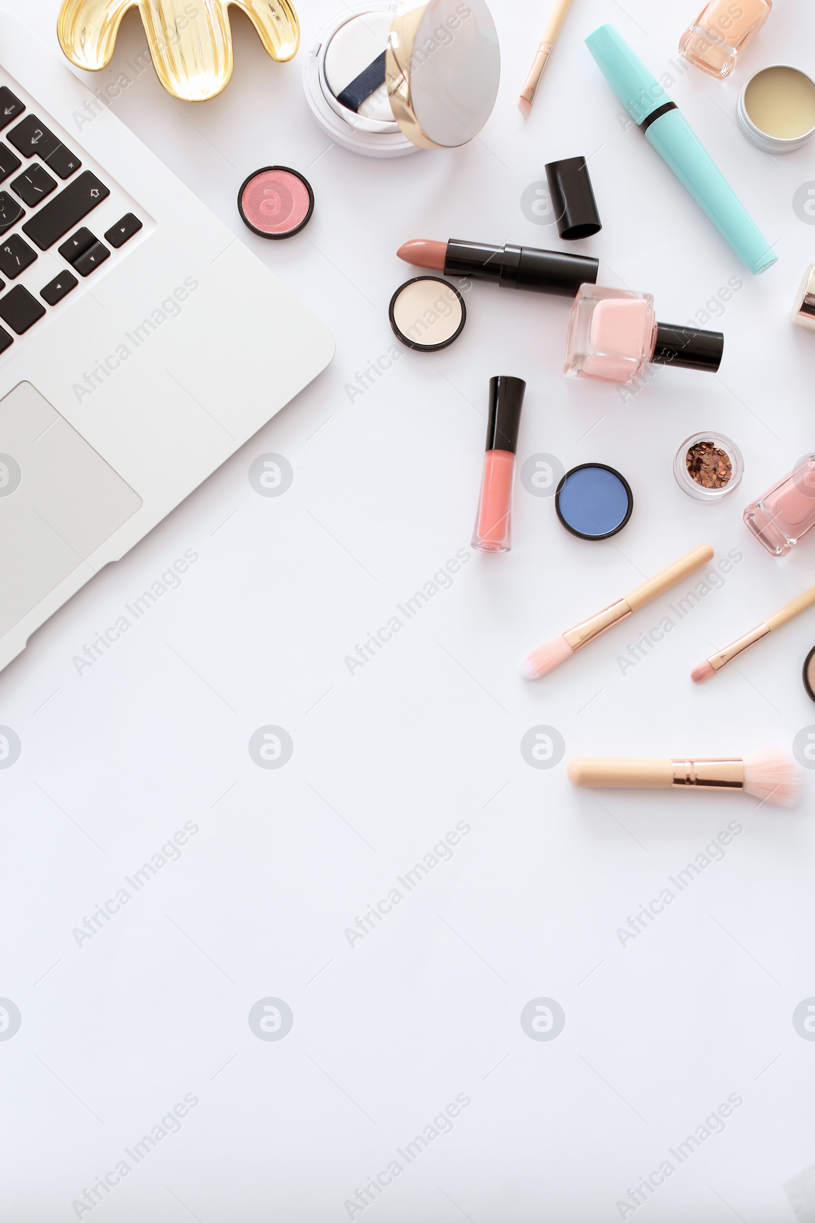 Photo of Flat lay composition with makeup products for woman and laptop on white background