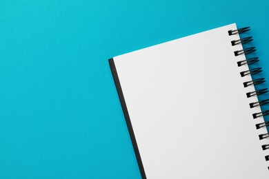 Photo of Blank notebook on light blue background, top view. Space for text