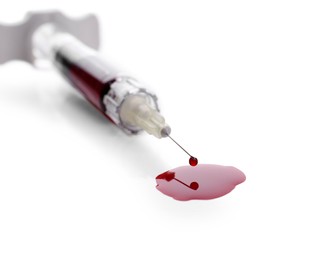 Plastic syringe with blood on white background