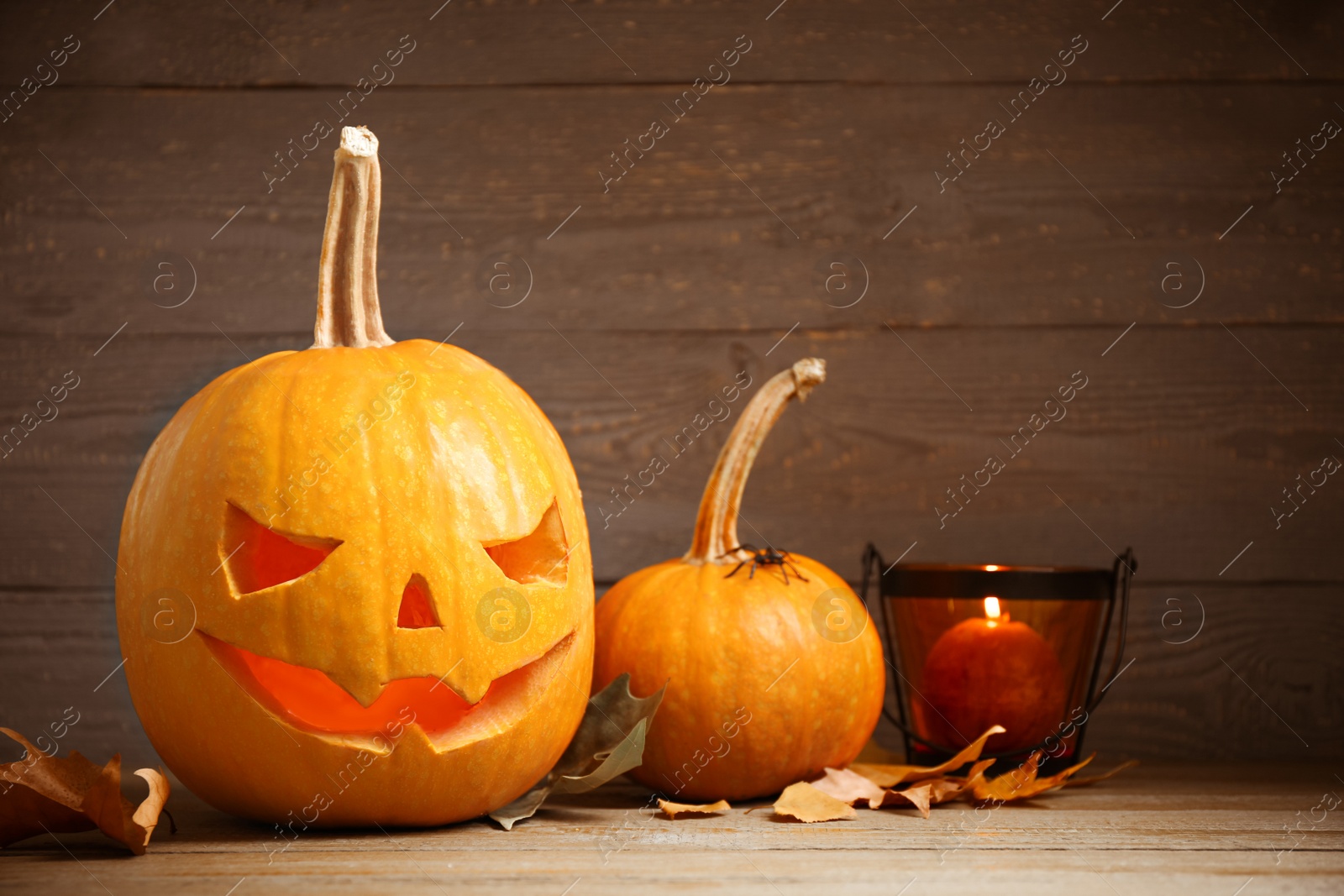 Photo of Spooky Jack pumpkin head lantern on wooden background. Halloween decoration