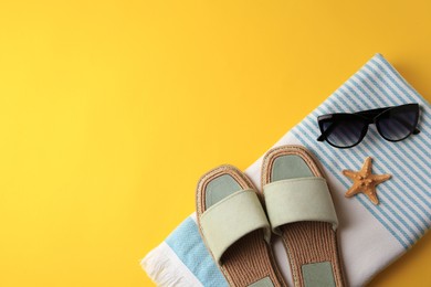 Flat lay composition with beach accessories on yellow background, space for text