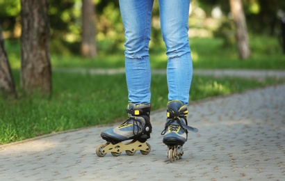 Photo of Man roller skating in summer park, closeup of legs