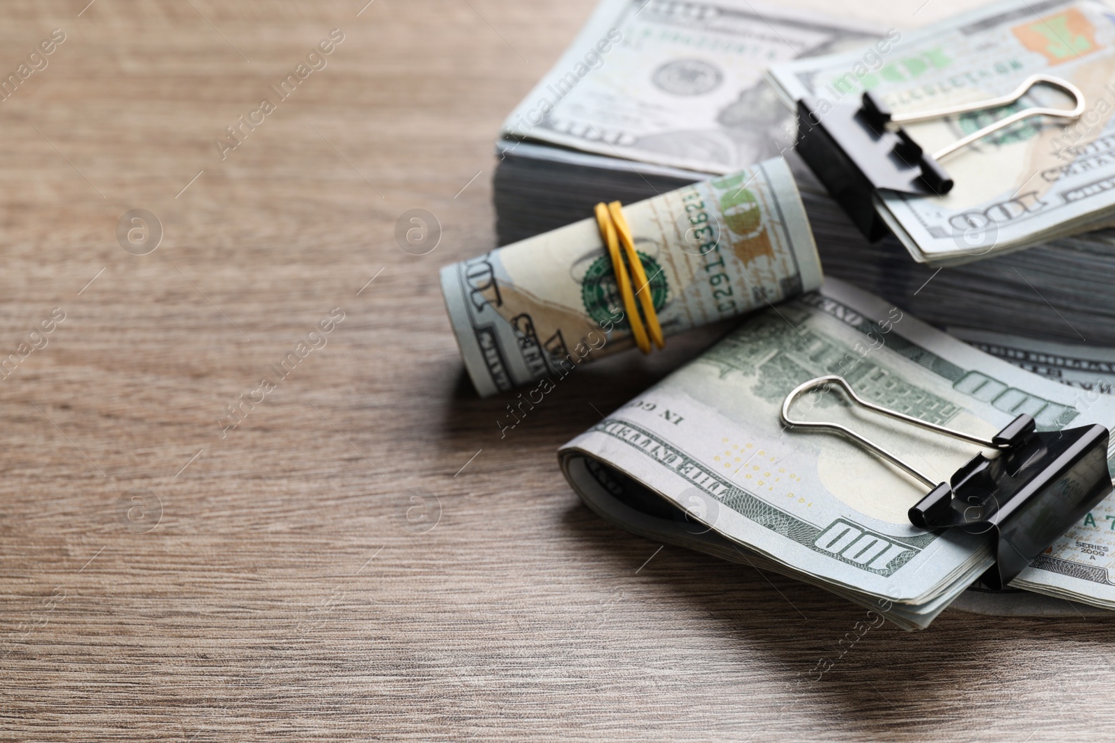 Photo of Many dollar banknotes on wooden table, closeup. Space for text