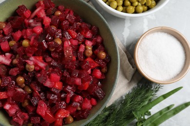 Photo of Bowl of delicious fresh vinaigrette salad and ingredients on light grey marble table, closeup