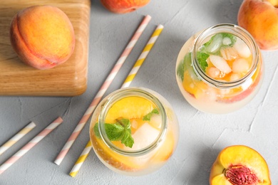 Tasty peach cocktail in glass jars on table. Refreshing drink