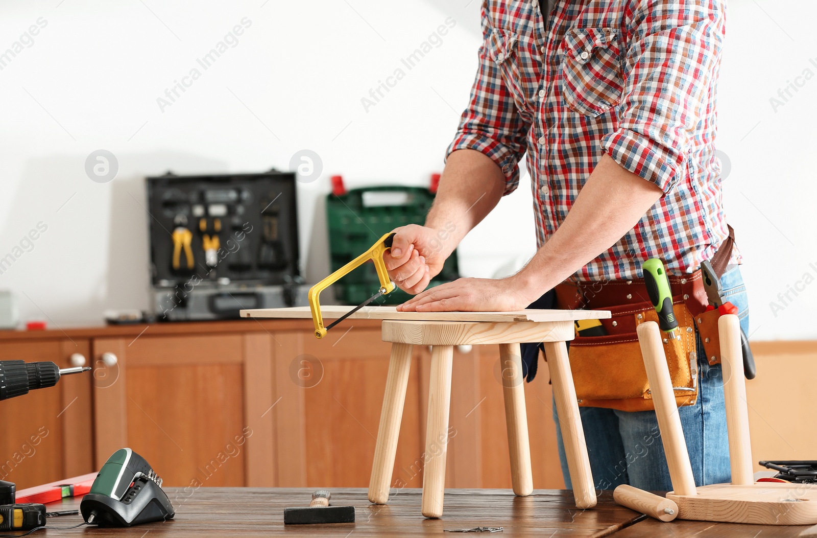 Photo of Man working with hand saw indoors, closeup. Home repair