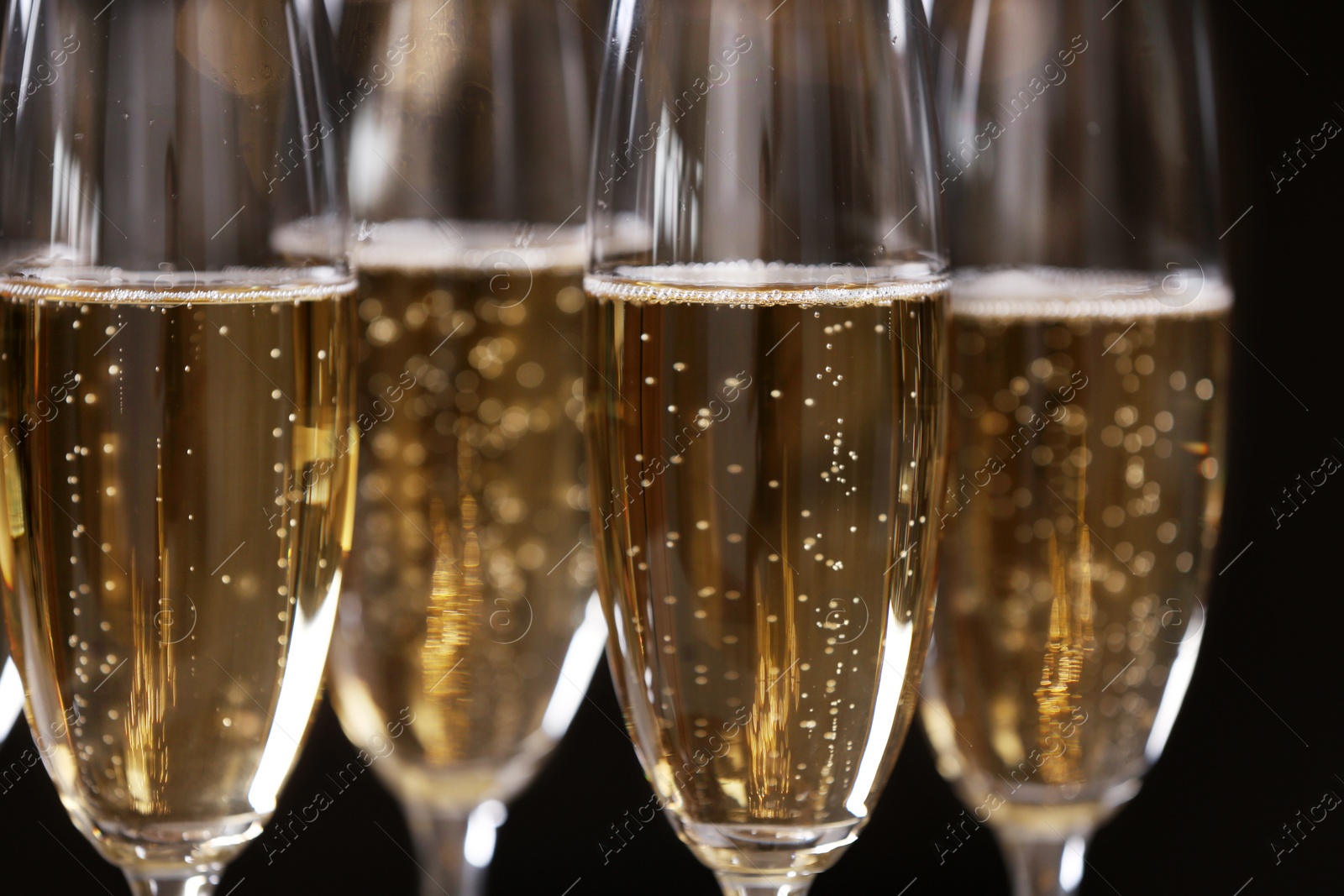 Photo of Glasses of champagne on dark background, closeup