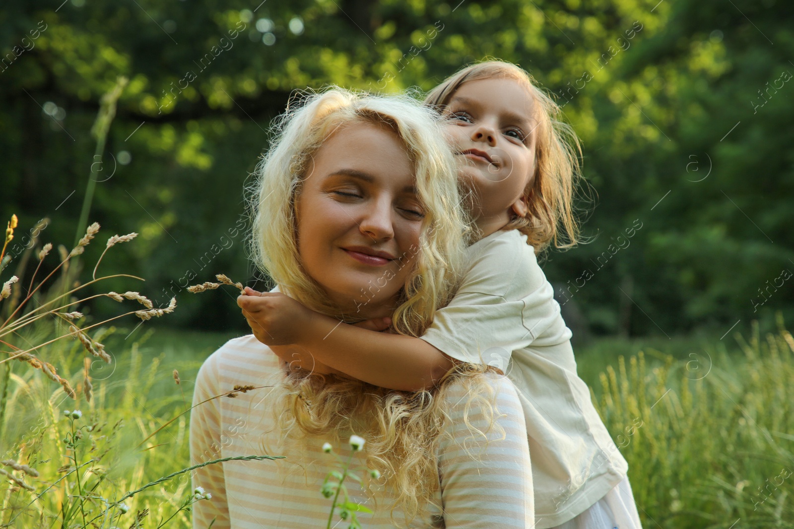 Photo of Beautiful mother with her cute daughter spending time together outdoors