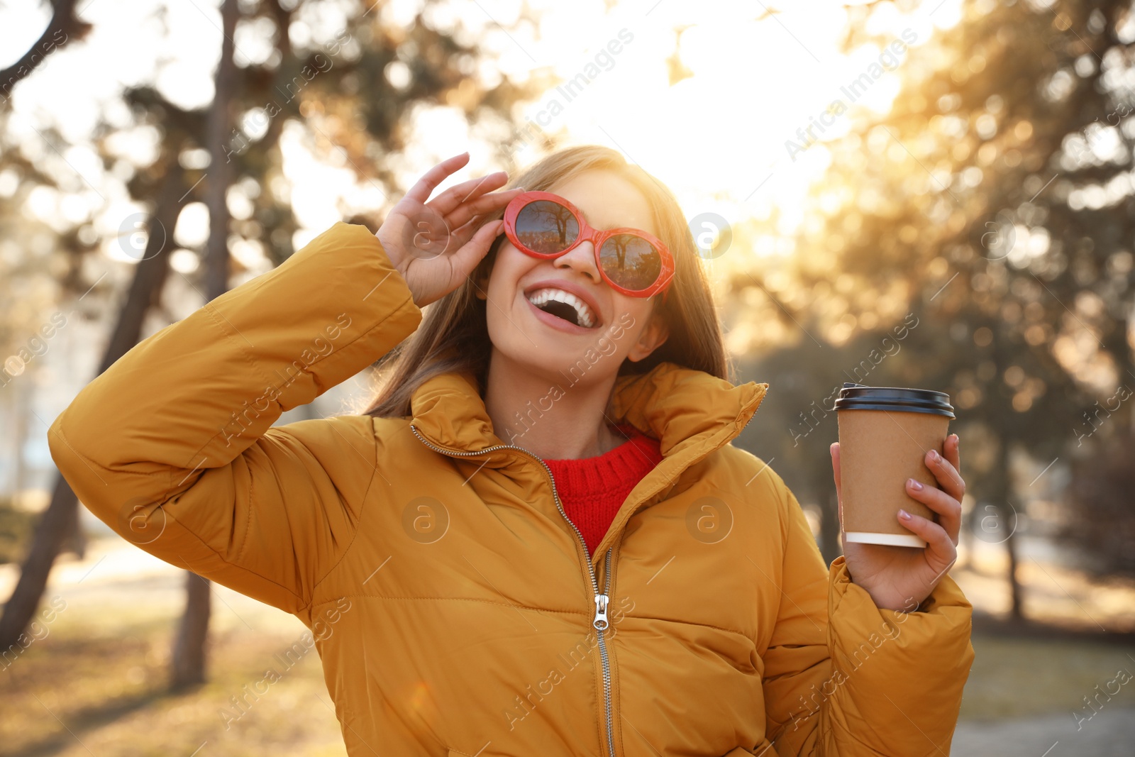 Photo of Young woman with cup of coffee in morning outdoors