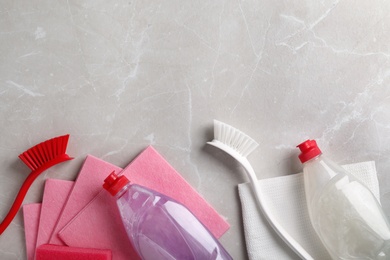 Photo of Flat lay composition with cleaning supplies for dish washing and space for text on grey background