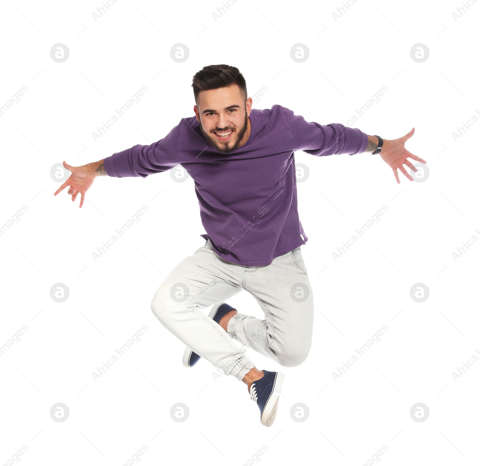 Photo of Handsome young man jumping on white background