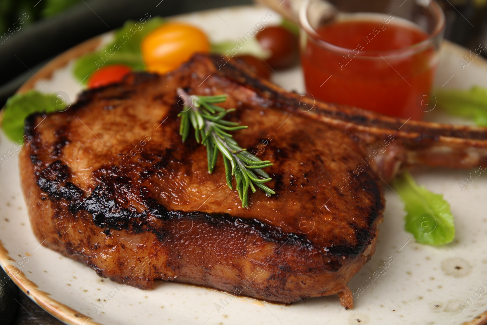 Photo of Tasty grilled meat, rosemary and marinade on plate, closeup