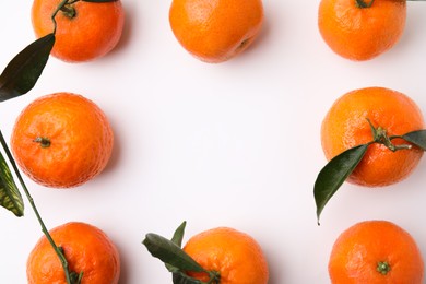 Frame made of many fresh ripe tangerines with leaves on white background, flat lay. Space for text
