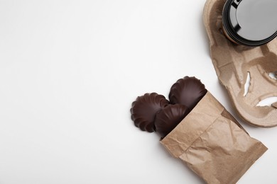Photo of Delicious chocolate covered zephyrs and paper cup on white table, flat lay. Space for text