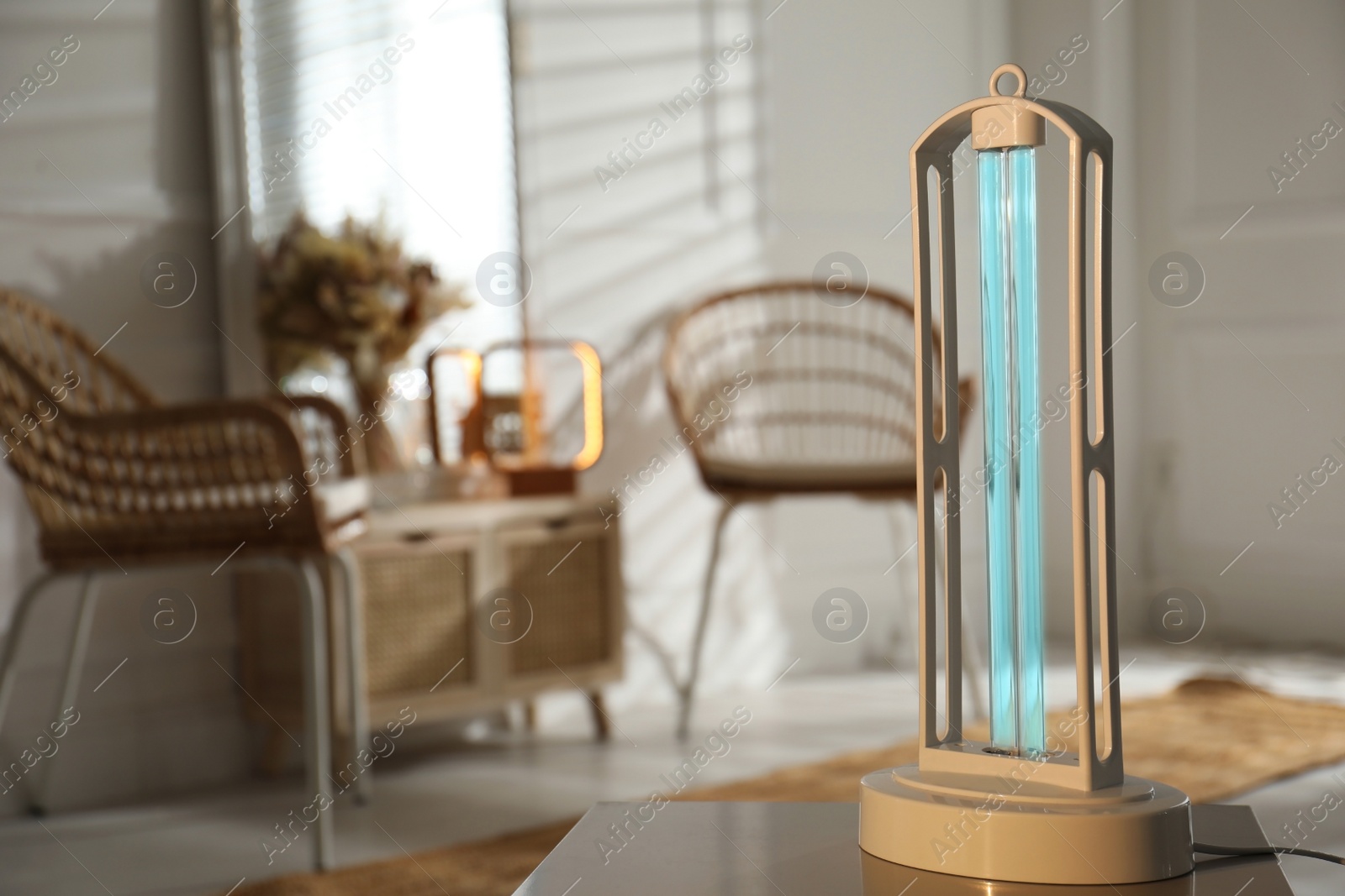 Photo of UV sterilizer lamp on table at home. Space for text