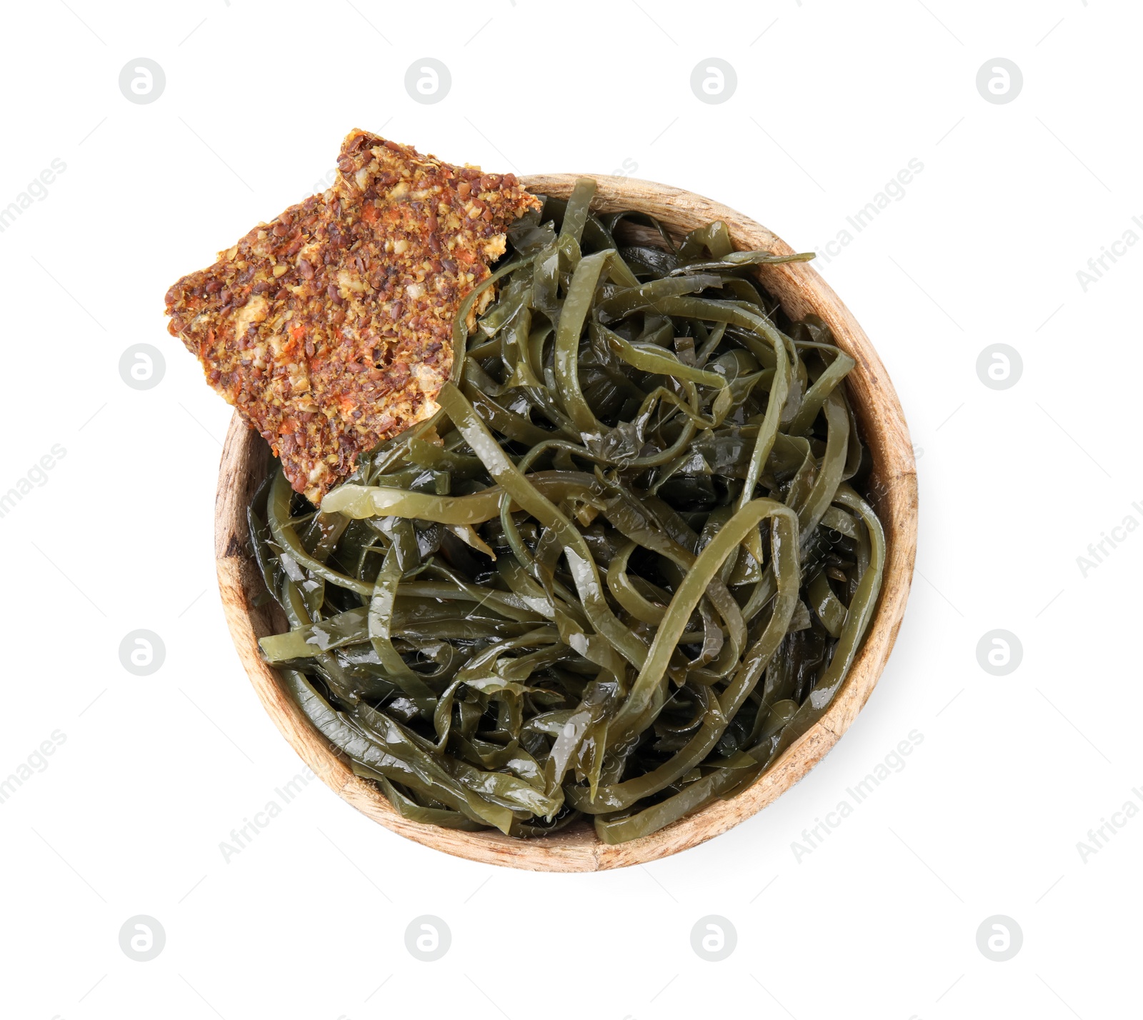 Photo of Tasty seaweed salad and crispbreads in bowl isolated on white, top view