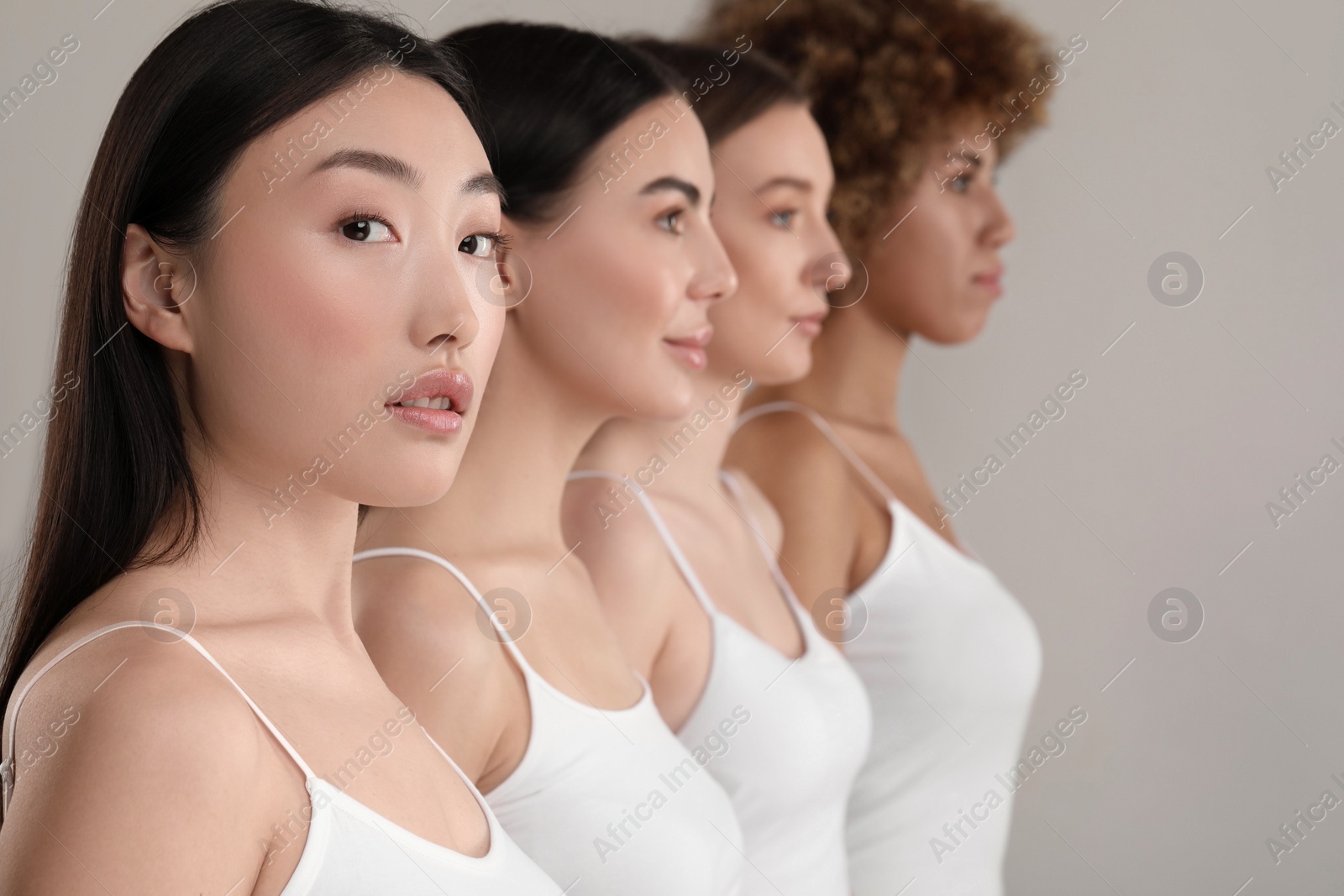 Photo of Beautiful young women with healthy skin on gray background