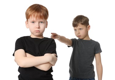 Photo of Boy pointing at upset kid on white background. Children's bullying