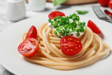 Photo of Delicious spaghetti with sour cream dressing on table, closeup